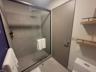 a shower with a glass door in a bathroom at Cosmopolitan APT 1407, 5 Star Facilities, 15m SJO Airport, Parking, Pool, Gym in San José