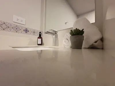a bathroom with a sink and a bottle of wine at Cosmopolitan APT 1407, 5 Star Facilities, 15m SJO Airport, Parking, Pool, Gym in San José