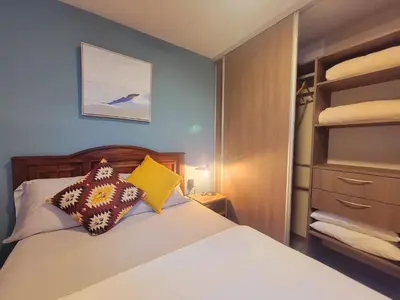 a small bedroom with a bed and a closet at Cosmopolitan APT 1407, 5 Star Facilities, 15m SJO Airport, Parking, Pool, Gym in San José