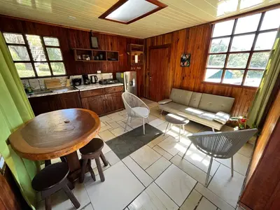 a kitchen and living room with a table and chairs at Pizote house in Monteverde Costa Rica