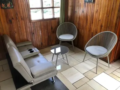 a room with two chairs and a couch and a table at Pizote house in Monteverde Costa Rica