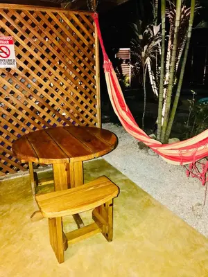 a wooden table and a bench next to a hammock at Anam Apartments in Santa Teresa Beach