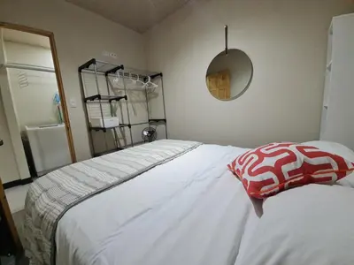 a bedroom with a white bed with a red and white pillow at Fully-equipped 2-bedroom apartment in San José in San José