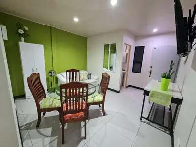 a dining room with a table and chairs and green walls at Fully-equipped 2-bedroom apartment in San José in San José