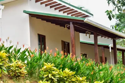 a house with a lot of flowers in front of it at Tarcoles Birding Lodge in Tarcoles