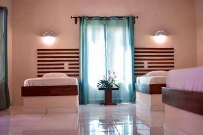 a hospital room with two beds and a window at Tarcoles Birding Lodge in Tarcoles