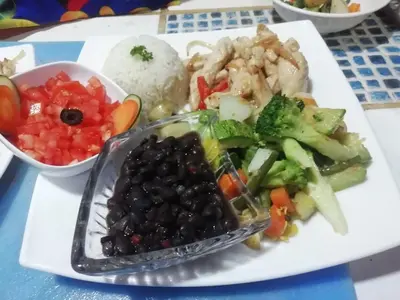 a plate of food with vegetables and rice on a table at Donde Familia Manito in Paquera