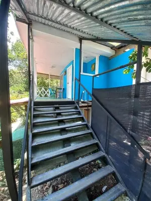 a set of stairs leading up to a blue house at Donde Familia Manito in Paquera