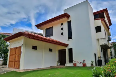 a white house with a red roof at Casa Lapa Oceanside Villa in Playa Hermosa