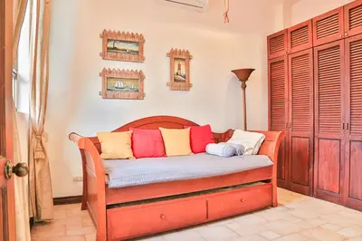 a room with a bed with colorful pillows on it at Casa Lapa Oceanside Villa in Playa Hermosa