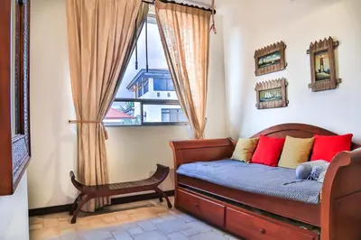 a small bedroom with a bed and a window at Casa Lapa Oceanside Villa in Playa Hermosa