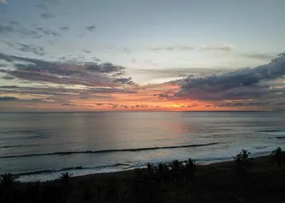 a sunset over the ocean with a beach at Casa Lapa Oceanside Villa in Playa Hermosa