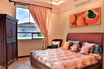 a bedroom with a bed and a large window at Casa Lapa Oceanside Villa in Playa Hermosa