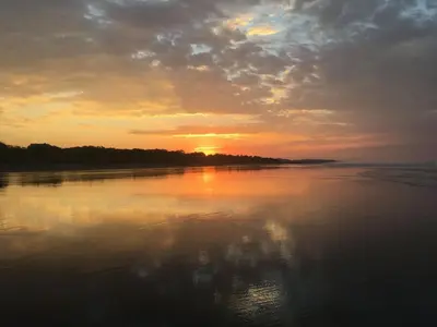 a sunset over a body of water with the sun setting at Casa Lapa Penthouse Oceanside Villa in Playa Hermosa