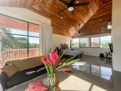 a living room with a couch and a ceiling fan at Casa Lapa Penthouse Oceanside Villa in Playa Hermosa