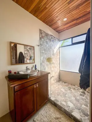 a bathroom with a sink and a glass shower at Casa Lapa Penthouse Oceanside Villa in Playa Hermosa