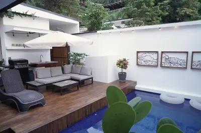 a patio with a couch and a table and chairs at Villa Taleona in Santa Teresa Beach