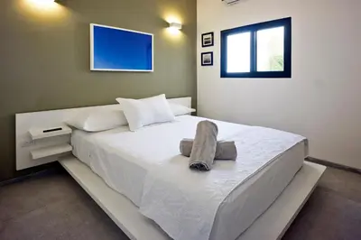 a bedroom with a white bed with a towel on it at Villa Taleona in Santa Teresa Beach