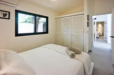 a bedroom with a white bed and a window at Villa Taleona in Santa Teresa Beach