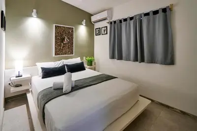 a bedroom with a large white bed and a window at Villa Taleona in Santa Teresa Beach