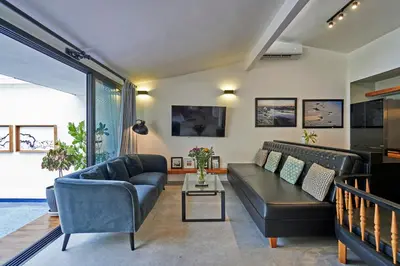 a living room with a couch and a table at Villa Taleona in Santa Teresa Beach