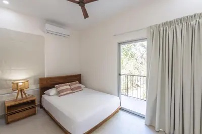 a bedroom with a bed and a large window at Villa Venus in Santa Teresa Beach