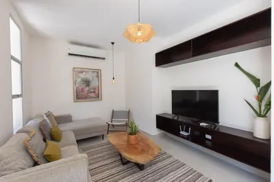 a living room with a couch and a tv at Villa Venus in Santa Teresa Beach