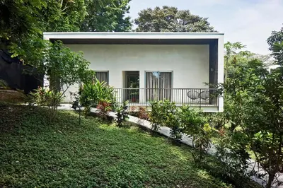 a small white house with a balcony in a yard at Villa Venus in Santa Teresa Beach