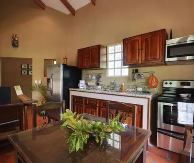 a kitchen with a table with a bowl of fruit on it at Unique Architecture, 3 Pools and Wi-Fi in Orotina
