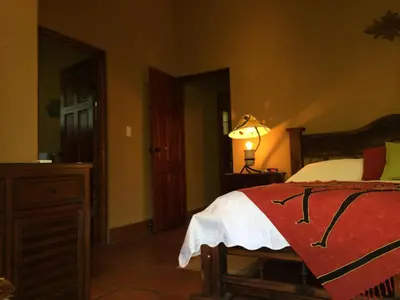 a bedroom with a bed and a lamp on a table at Unique Architecture, 3 Pools and Wi-Fi in Orotina