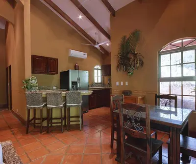 a large kitchen with a table and chairs in a room at Unique Architecture, 3 Pools and Wi-Fi in Orotina