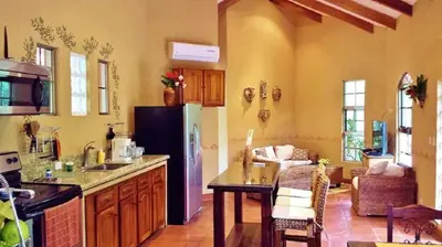 a kitchen with a refrigerator and a table in a room at Unique Architecture, 3 Pools and Wi-Fi in Orotina