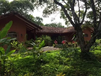 a house with a garden in front of it at Unique Architecture, 3 Pools and Wi-Fi in Orotina