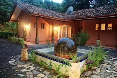 a house with a fountain in front of it at Private Pool & WiFi in Puntarenas