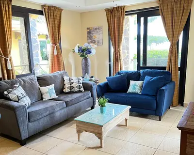 a living room with blue couches and a coffee table at BEACHFRONT Condo Bahia Encantada L1 Jaco Beach in Jacó