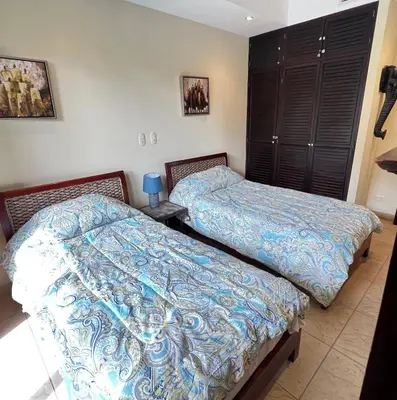 a bedroom with two beds and a night stand at BEACHFRONT Condo Bahia Encantada L1 Jaco Beach in Jacó