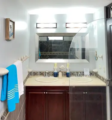 a bathroom with two sinks and a mirror at BEACHFRONT Condo Bahia Encantada L1 Jaco Beach in Jacó