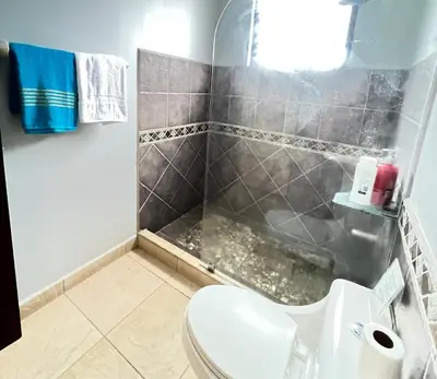 a bathroom with a toilet and a shower at BEACHFRONT Condo Bahia Encantada L1 Jaco Beach in Jacó