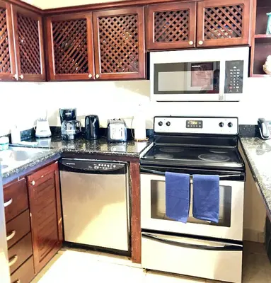 a kitchen with a stove and a microwave at BEACHFRONT Condo Bahia Encantada L1 Jaco Beach in Jacó