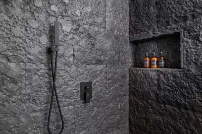 a bathroom with a shower with four bottles of beer at LALOON Luxury Suites - Adults Only in Santa Teresa Beach