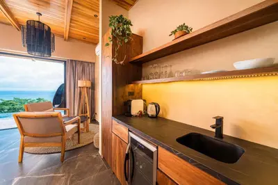 a kitchen with a sink and a view of the ocean at LALOON Luxury Suites - Adults Only in Santa Teresa Beach