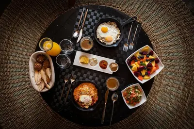 a table topped with plates of breakfast foods and drinks at LALOON Luxury Suites - Adults Only in Santa Teresa Beach