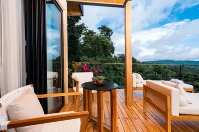 a room with a balcony with a table and chairs at LALOON Luxury Suites - Adults Only in Santa Teresa Beach