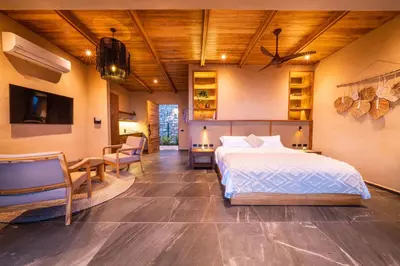 a bedroom with a bed and a table and chairs at LALOON Luxury Suites - Adults Only in Santa Teresa Beach