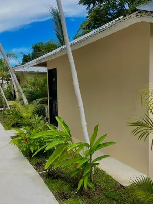 a house with a palm tree in front of it at Grand Park Manuel Antonio - Adults Only in Manuel Antonio