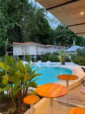 a swimming pool with two tables and two chairs at Grand Park Manuel Antonio - Adults Only in Manuel Antonio