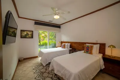 a bedroom with two beds and a window at Veranda 6F 2 bdr Garden View in Los Suenos in Herradura