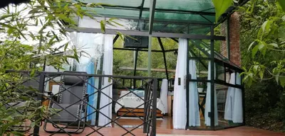 a glass extension to a house with a patio at Cristal House Mountain View in Heredia