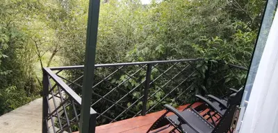 a balcony with chairs and trees on a house at Cristal House Mountain View in Heredia
