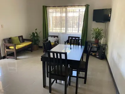 a dining room with a table and chairs and a couch at Casa Binisa Fresca y agradable in Liberia